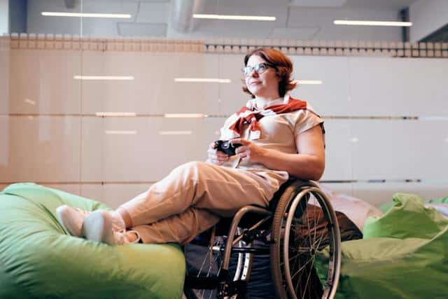 A woman in a wheelchair enjoying the comfort of a bean bag in her home.