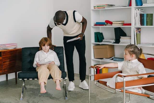 A teacher spends time with two neurodivergent children, teaching them in a more informal setting than a typical classroom