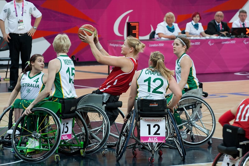 A group of women engaged in wheelchair basketball. The Aussie Rollers and Aussie Gliders are the Australian teams.