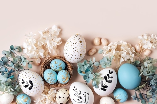 Inclusive Easter eggs on a beige background, surrounded by flowers.