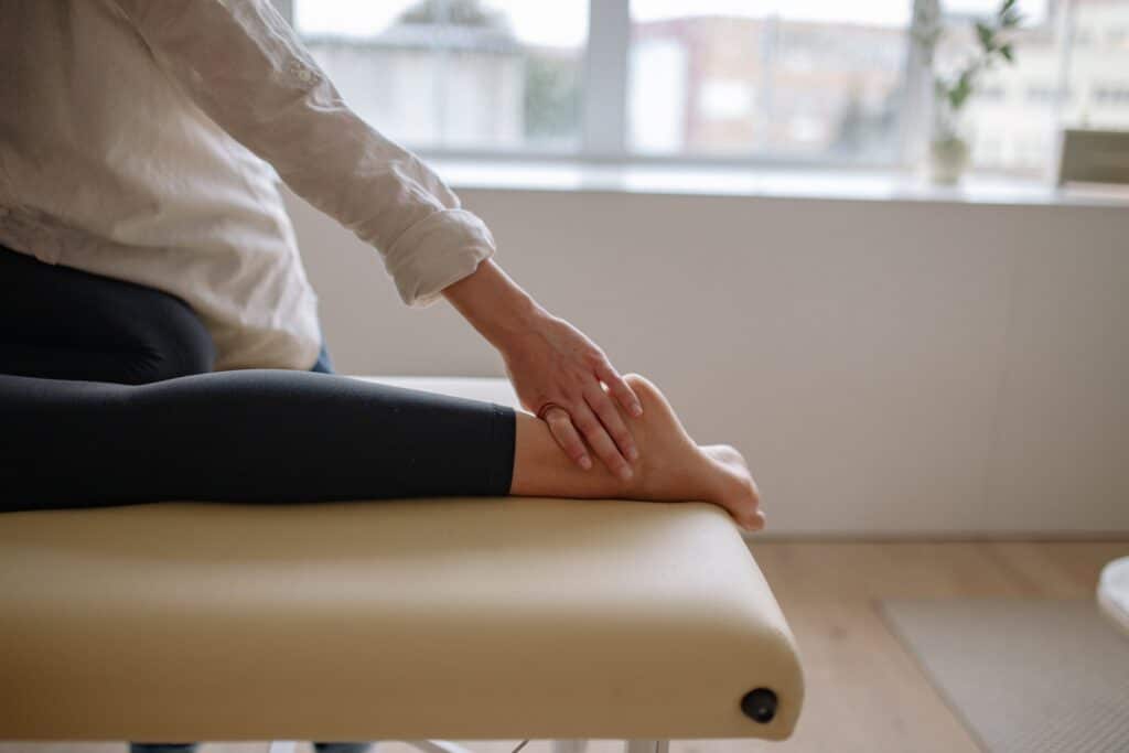 A therapist massaging a person with disability's feet.