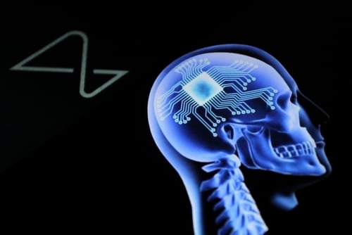 X-ray style image of a human skull with a digital microchip and circuitry superimposed on the brain, representing the latest Neuralink brain-computer interface technology in this 2026 update.